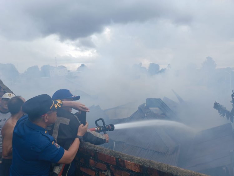 Petugas Damkar sedang berjibaku memadamkan Api sebuah rumah yang terbakar di Jalan Pemuda.Foto: Gotvnews/Hasandy.