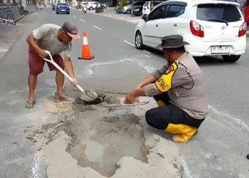 Salut, Warga dan Bhabinkamtibmas Gotong Royong Perbaiki Jalan Berlubang di Tanjungpinang